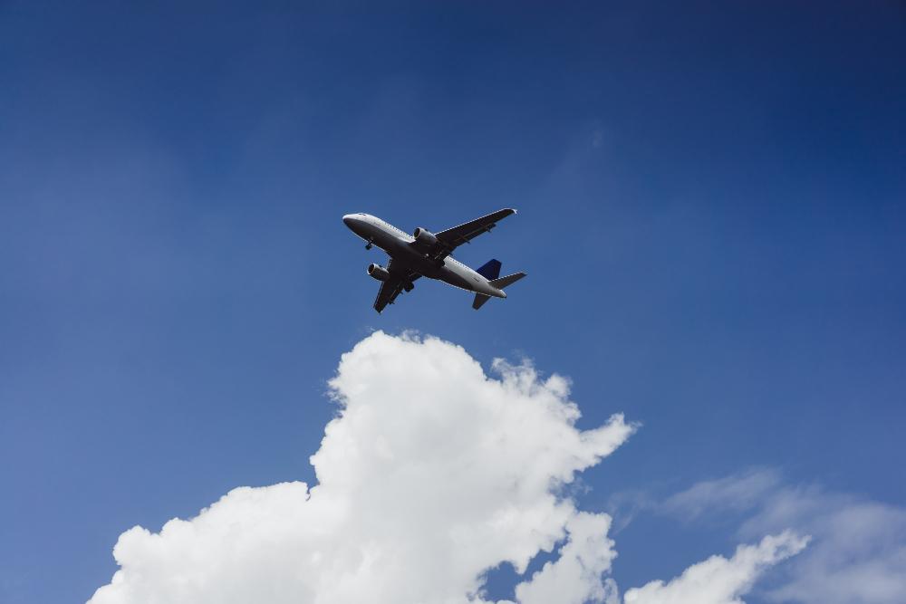 A small plane photographed during mid-flight as it passes a collection of clouds