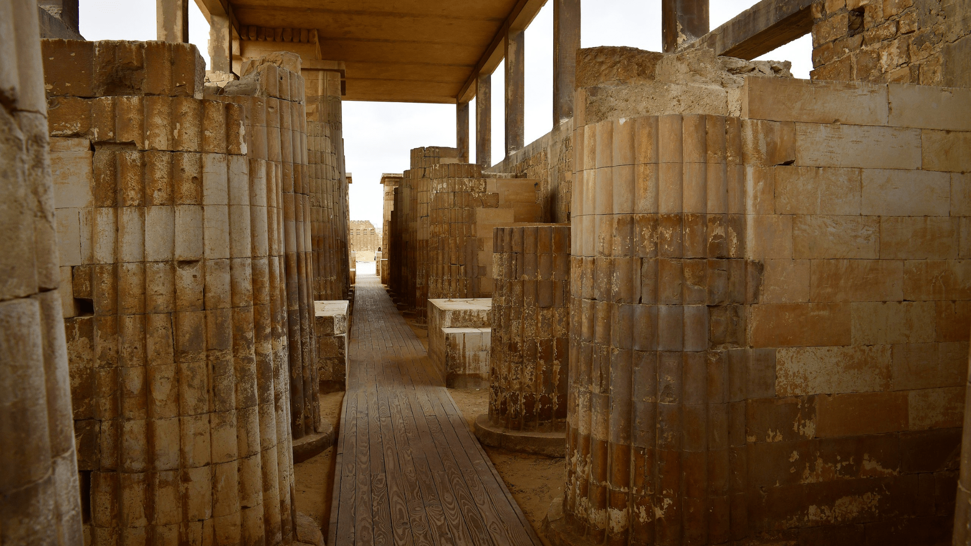 Colonnaded entrance to Djoser's step pyramid complex at Saqqara. Partially preserved columns rise on either side of the photograph.