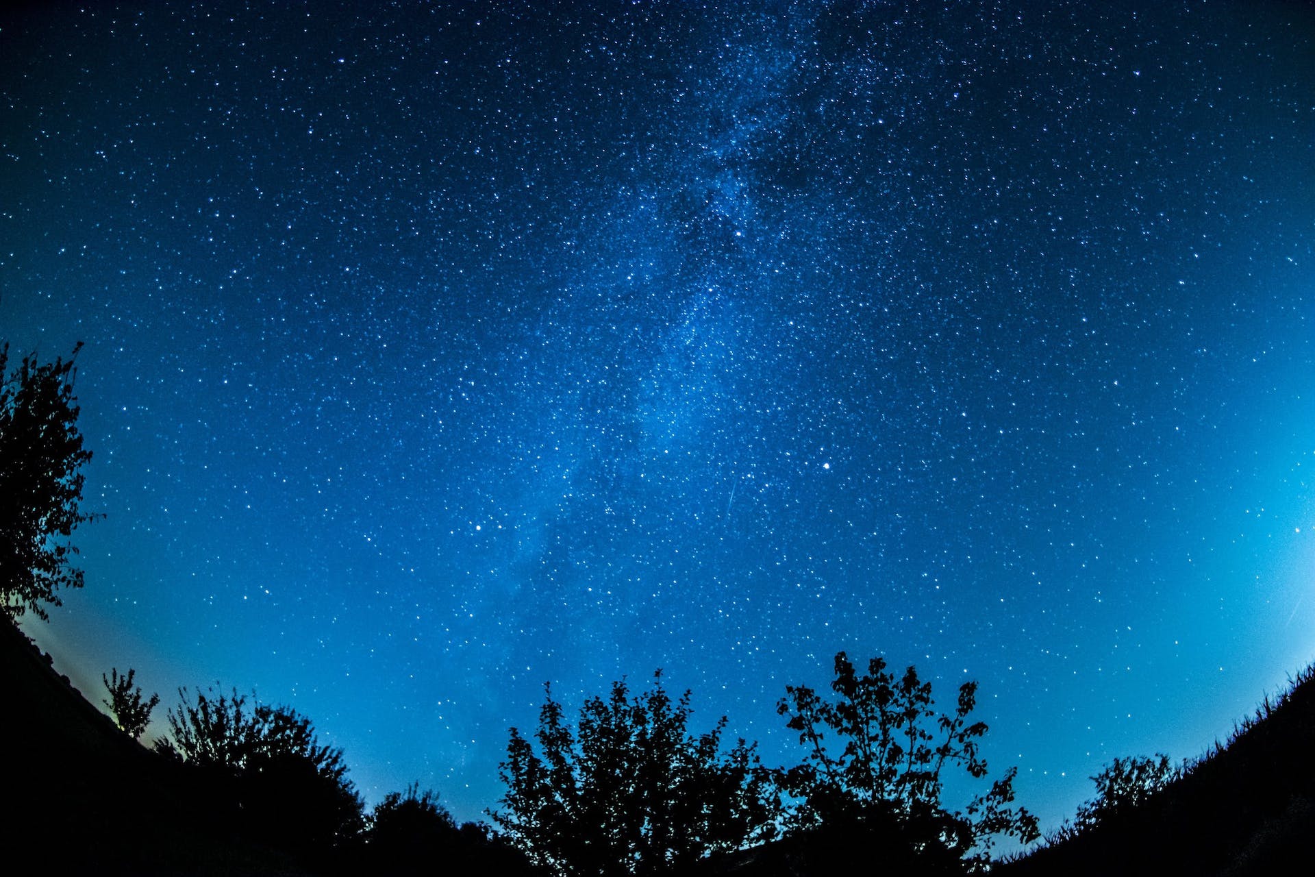A faint image of the Milky Way in a blue night sky
