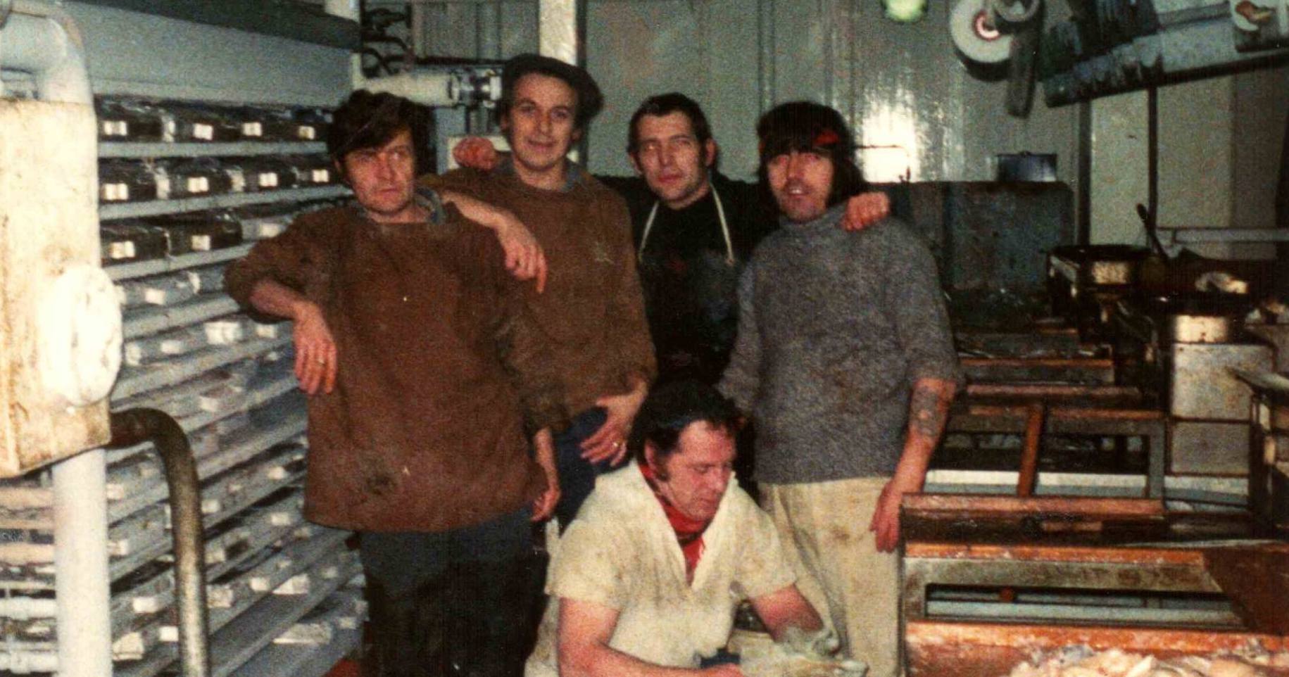 Five men posing together below the deck of a ship