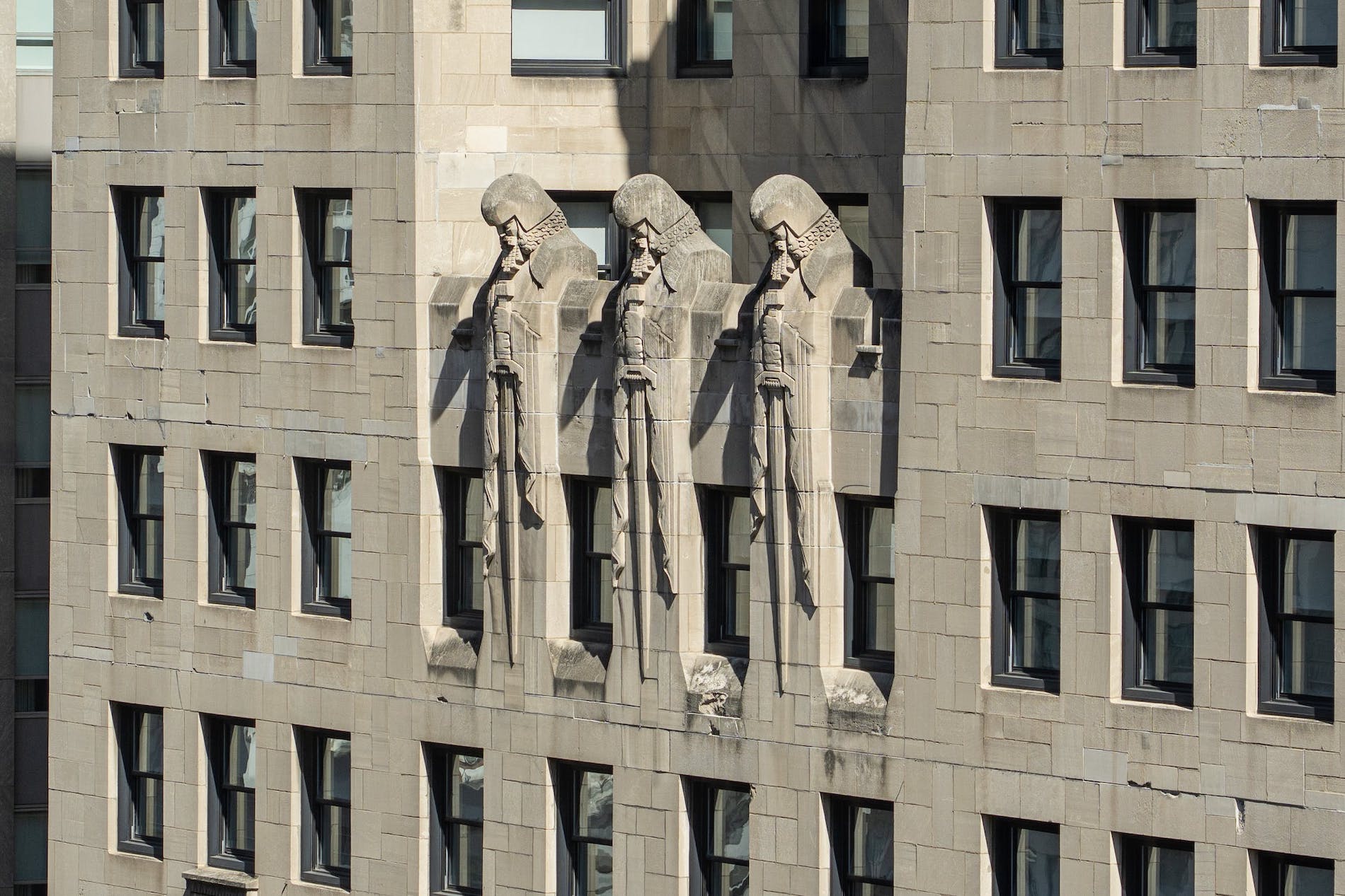 Three knight sculptures overlooking a large stone building