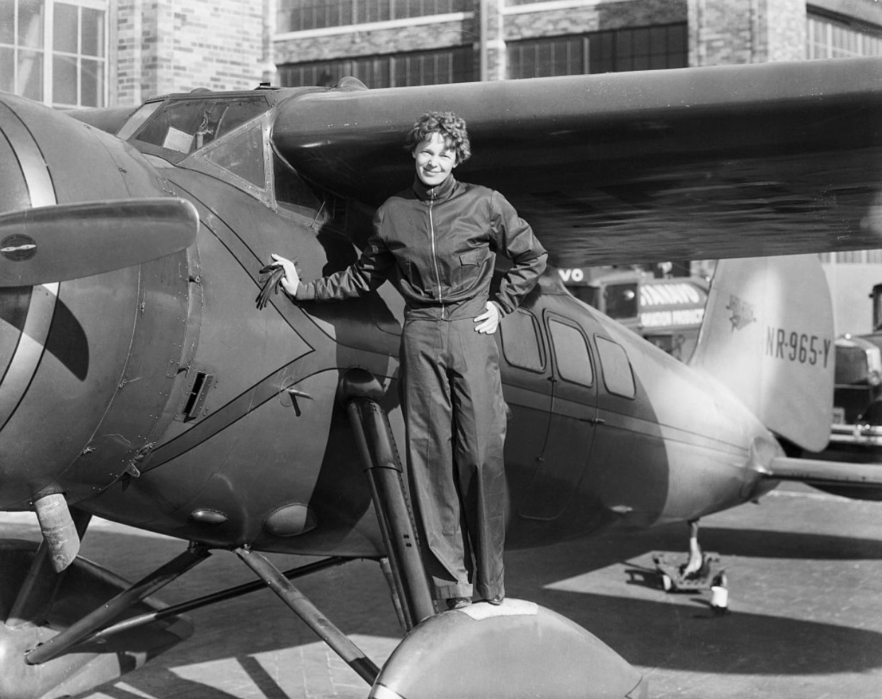 Amelia Earhart (1898-1937), American aviatrix, next to her aircraft