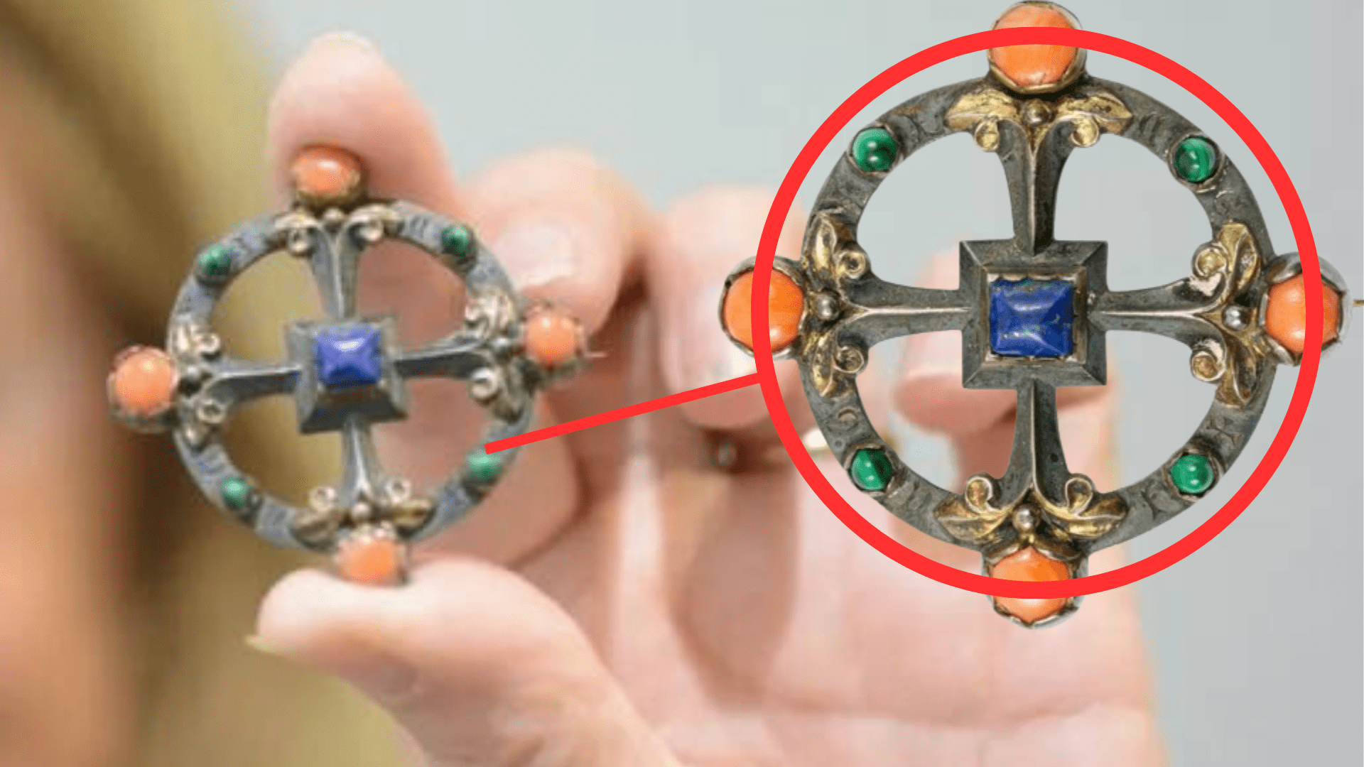 Flora Steel holds up her brooch. Only her hand and the brooch are visible. They are blurred in the background. A red line leads to a red circle that encompasses a clarified image of the brooch.