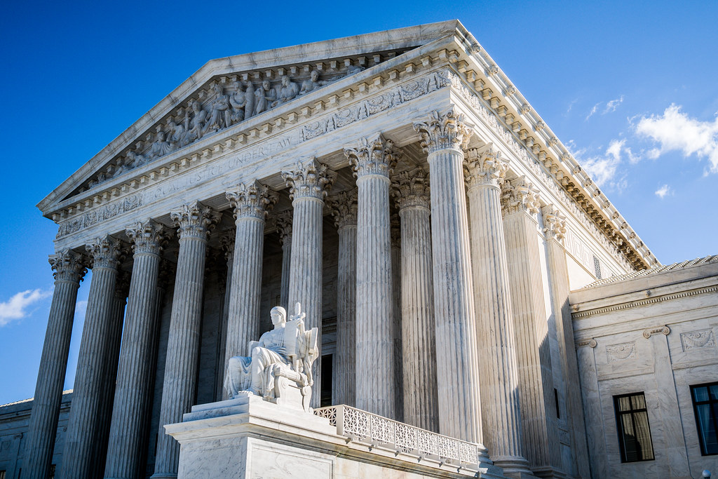 An angled shot of a large white stone building with columns.