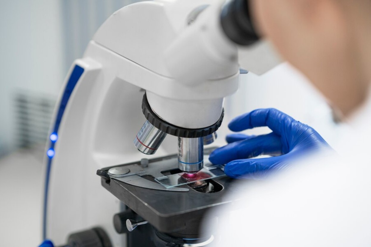 Scientist examining a sample under a microscope