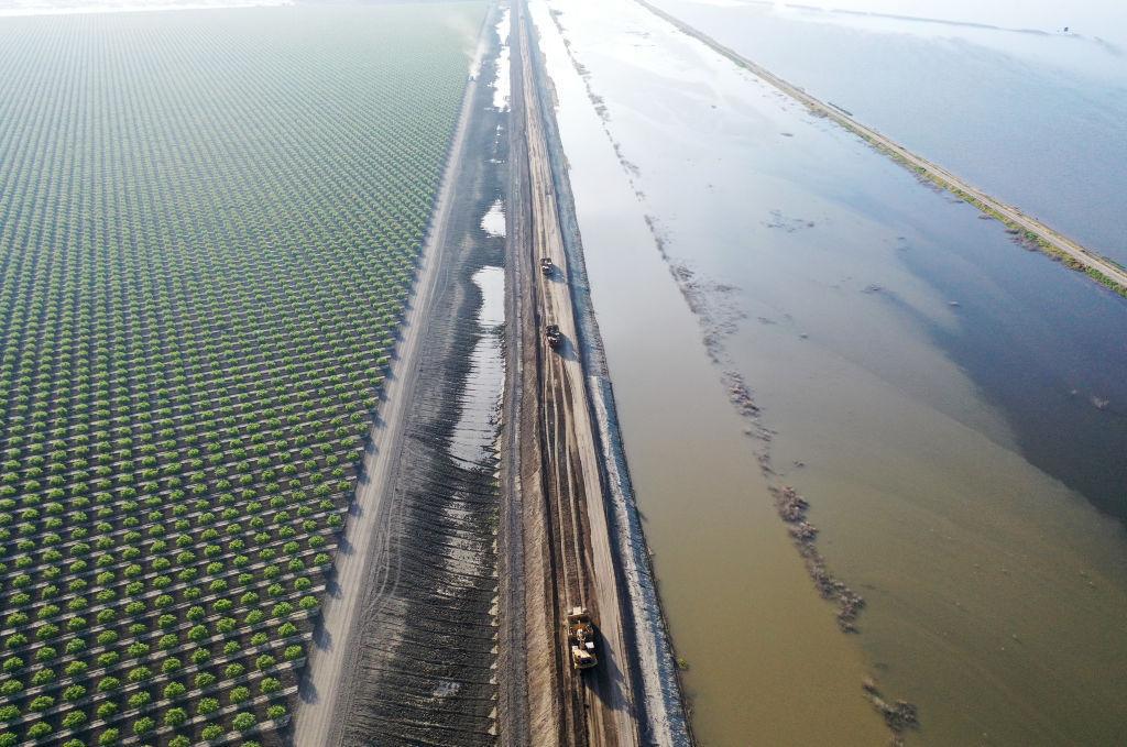 In an aerial view, earth movers work to raise the Corcoran Levee in response to flood waters along the reemerging Tulare Lake