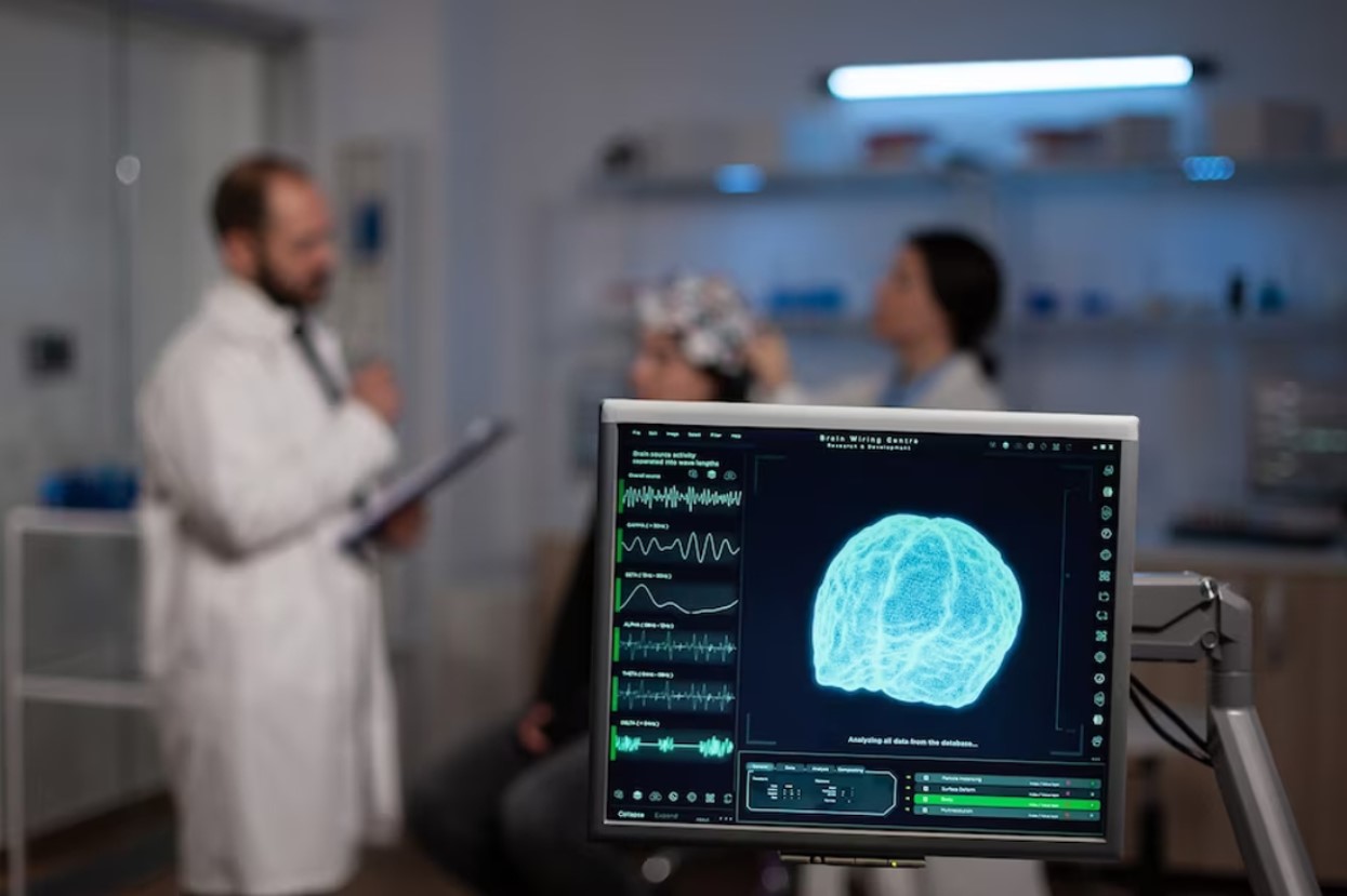 Doctors studying a brain in an exam room with a screen showing the details