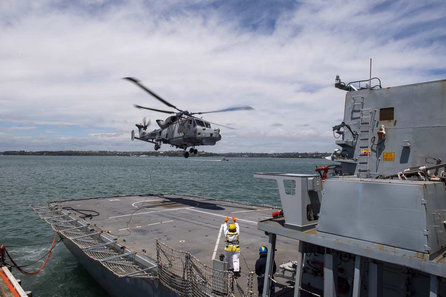A helicopter landing on a ship in the ocean