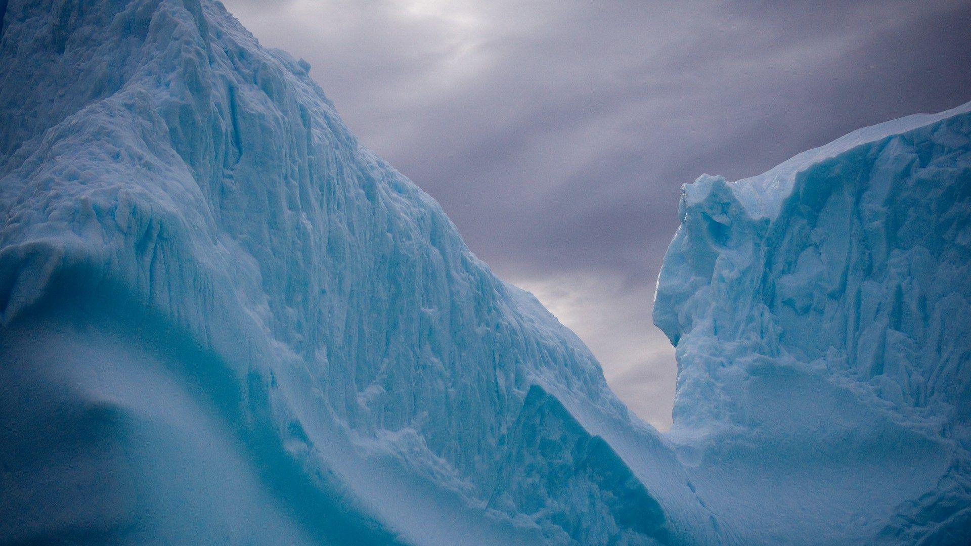 A close-up view of massive ice glacier mountains in Antarctica.