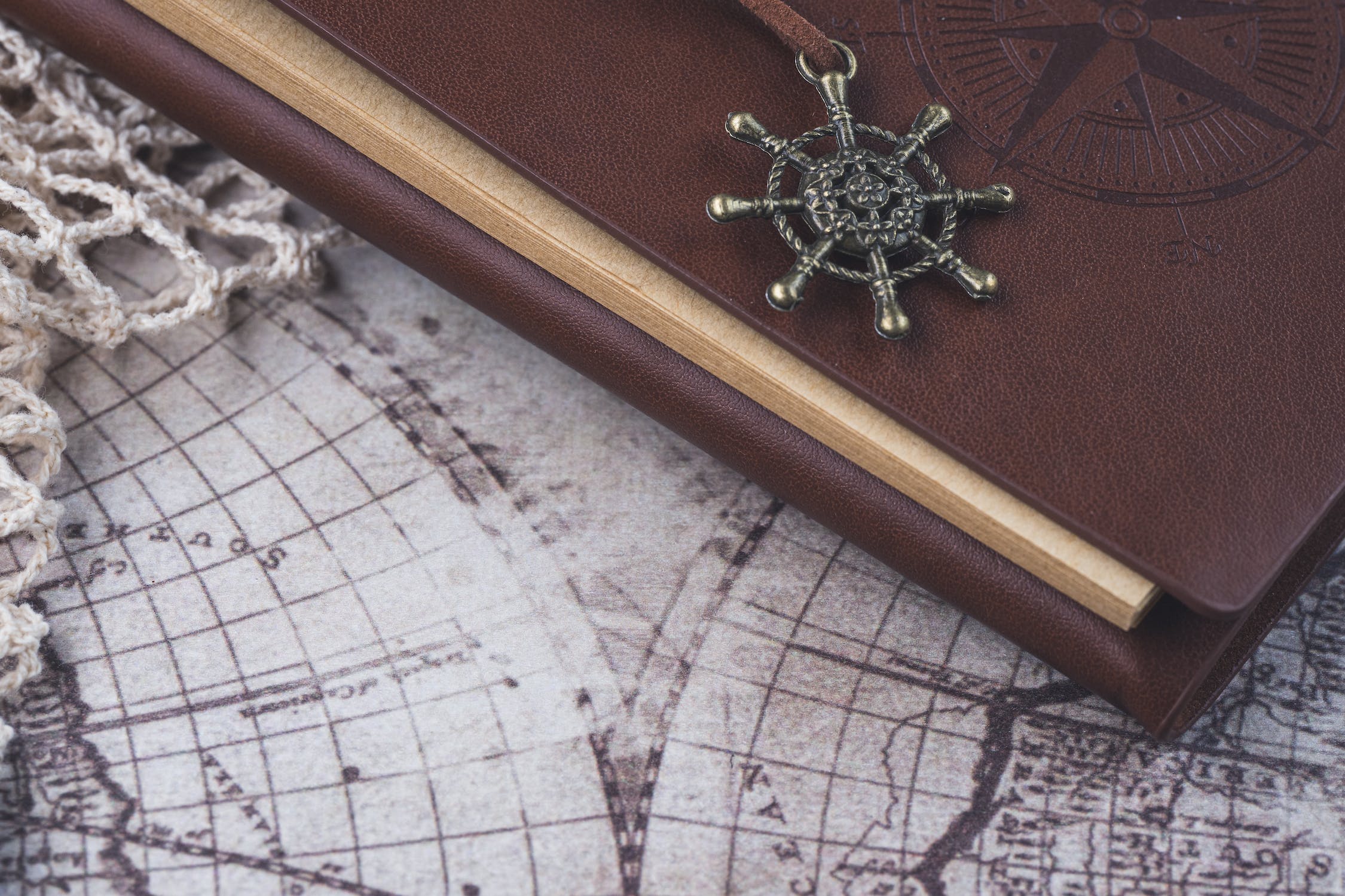 A brown notebook sitting on top of a vintage map