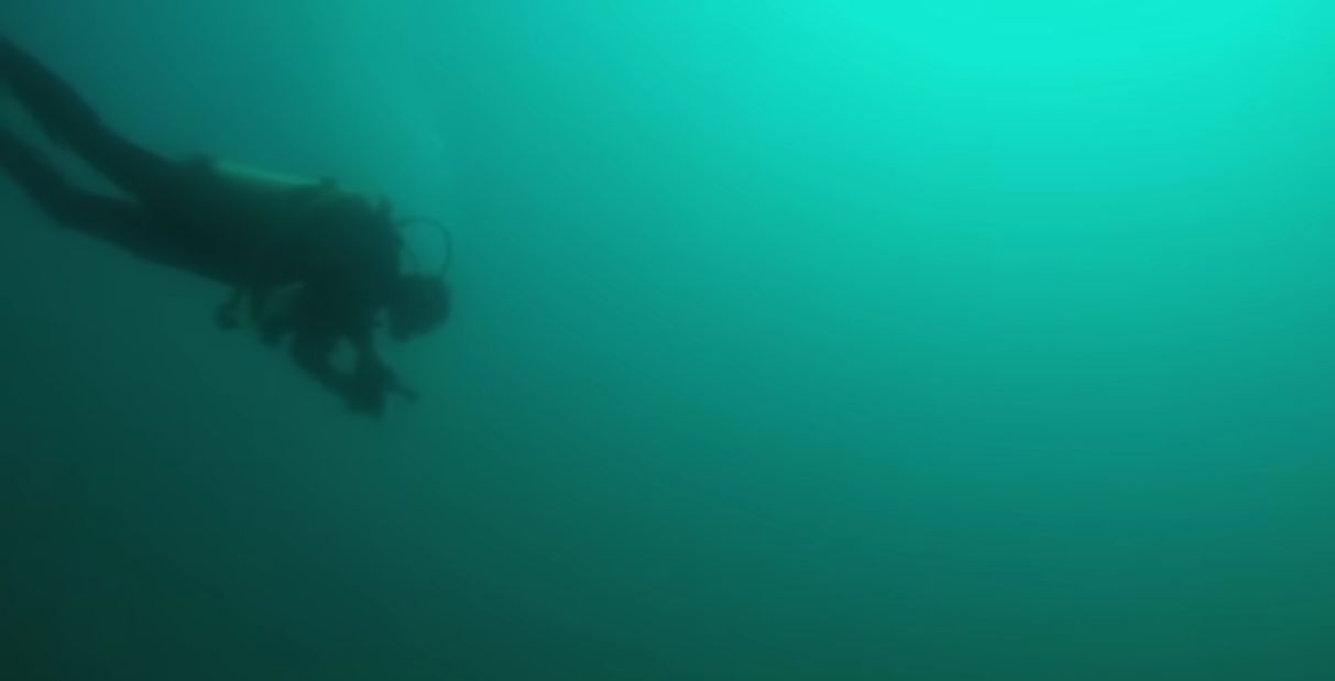 Screenshot of a YouTube video by @DiscoveryUK of scuba diver exploring the underwater rock formation in Lake Michigan