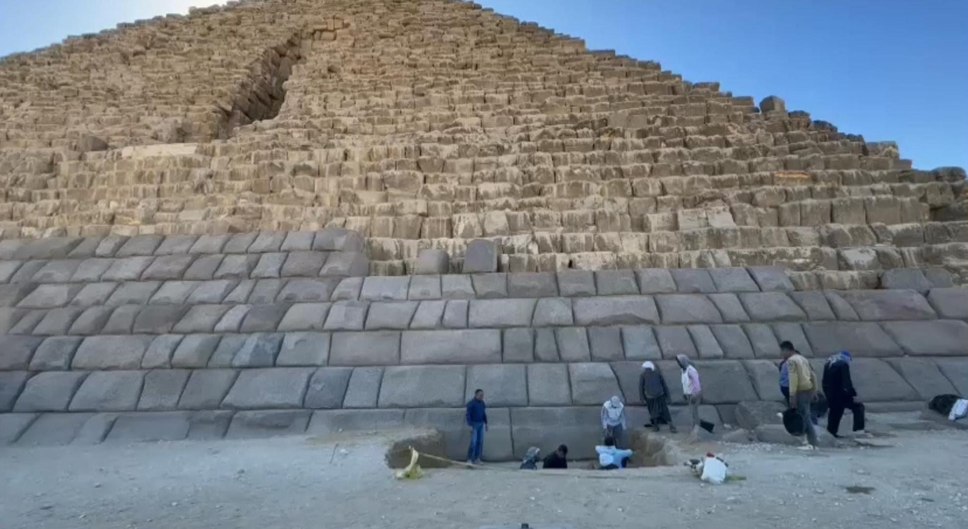 Waziry and his team pictured digging beneath the surface at the Pyramid of Menkaure