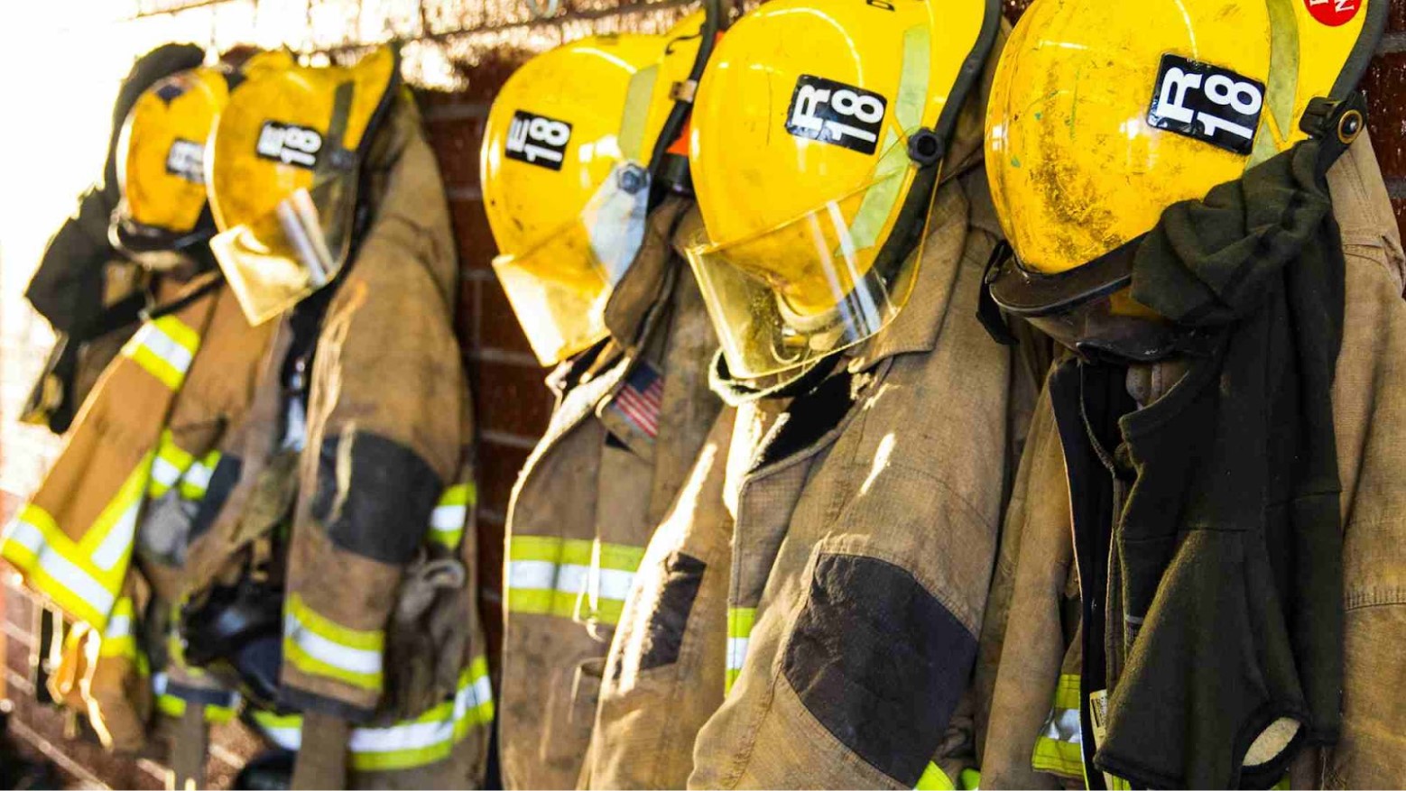 Firefighter uniforms hanging on hooks