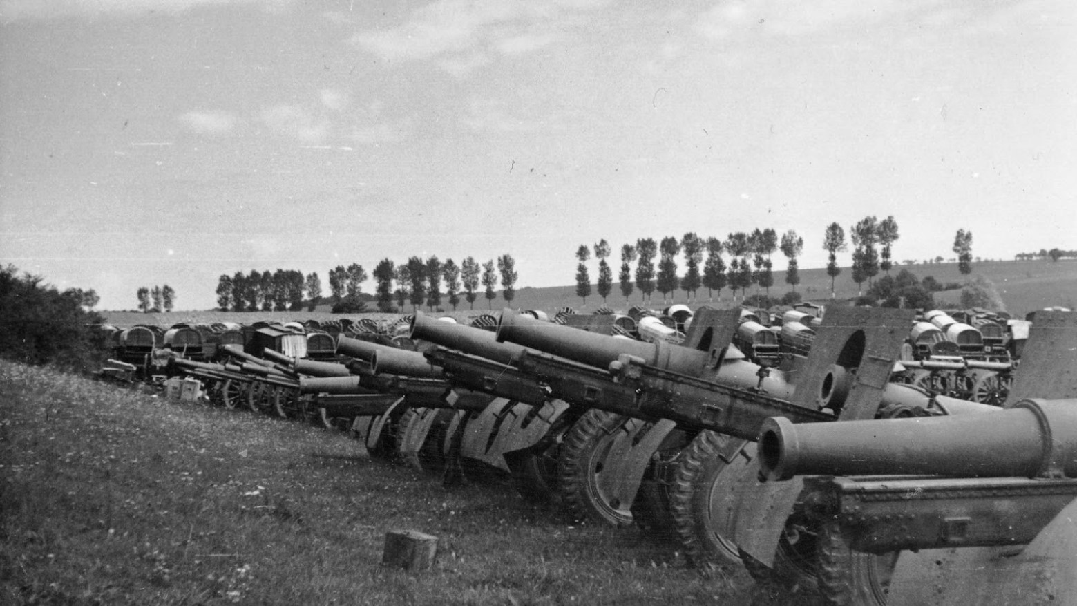 A black and white photo of a row of military cannons and tanks in the countryside during the beginning of Operation Barbarossa in World War II.