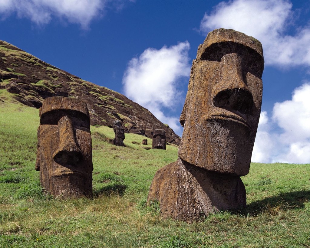The Easter Island heads made of stone in the grass of an island