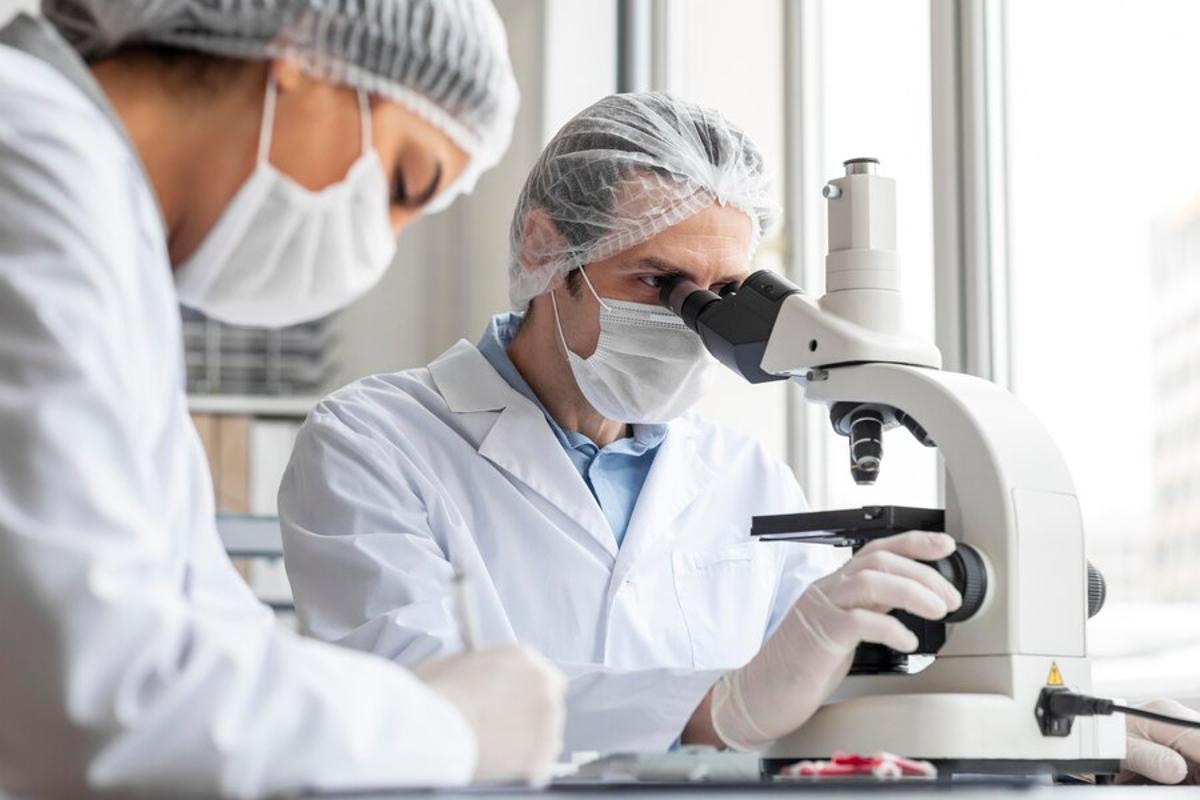 Scientists studying findings with a microscope