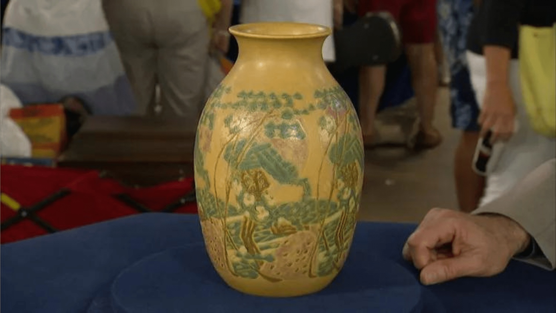 Vase from an Indiana Goodwill sitting on a blue padded surface at Antiques Roadshow.