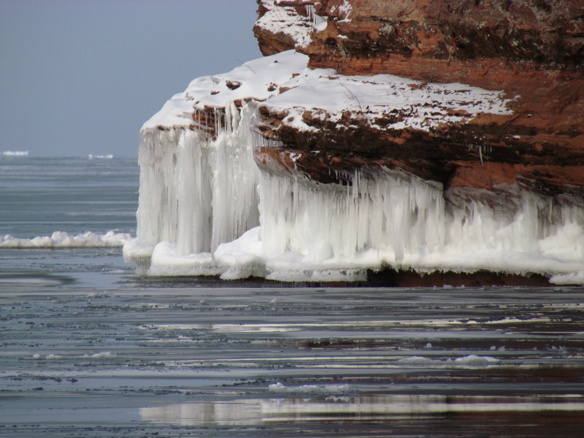 Lake Superior in the winter with a large cluster of icicles hanging from a cliff