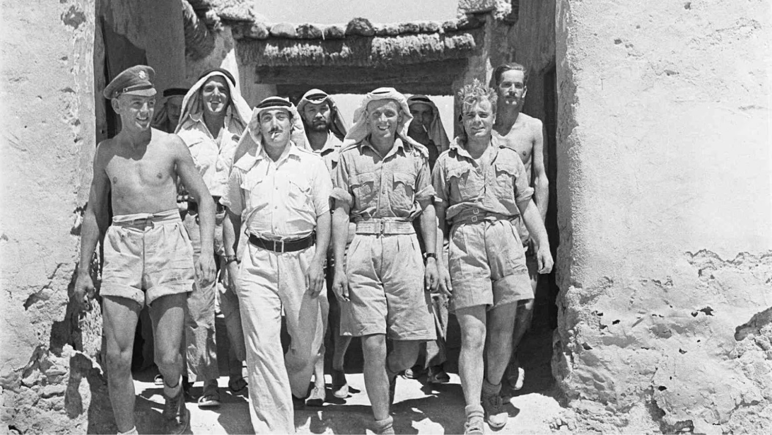 Members of a Long Range Desert Group walking by a building.
