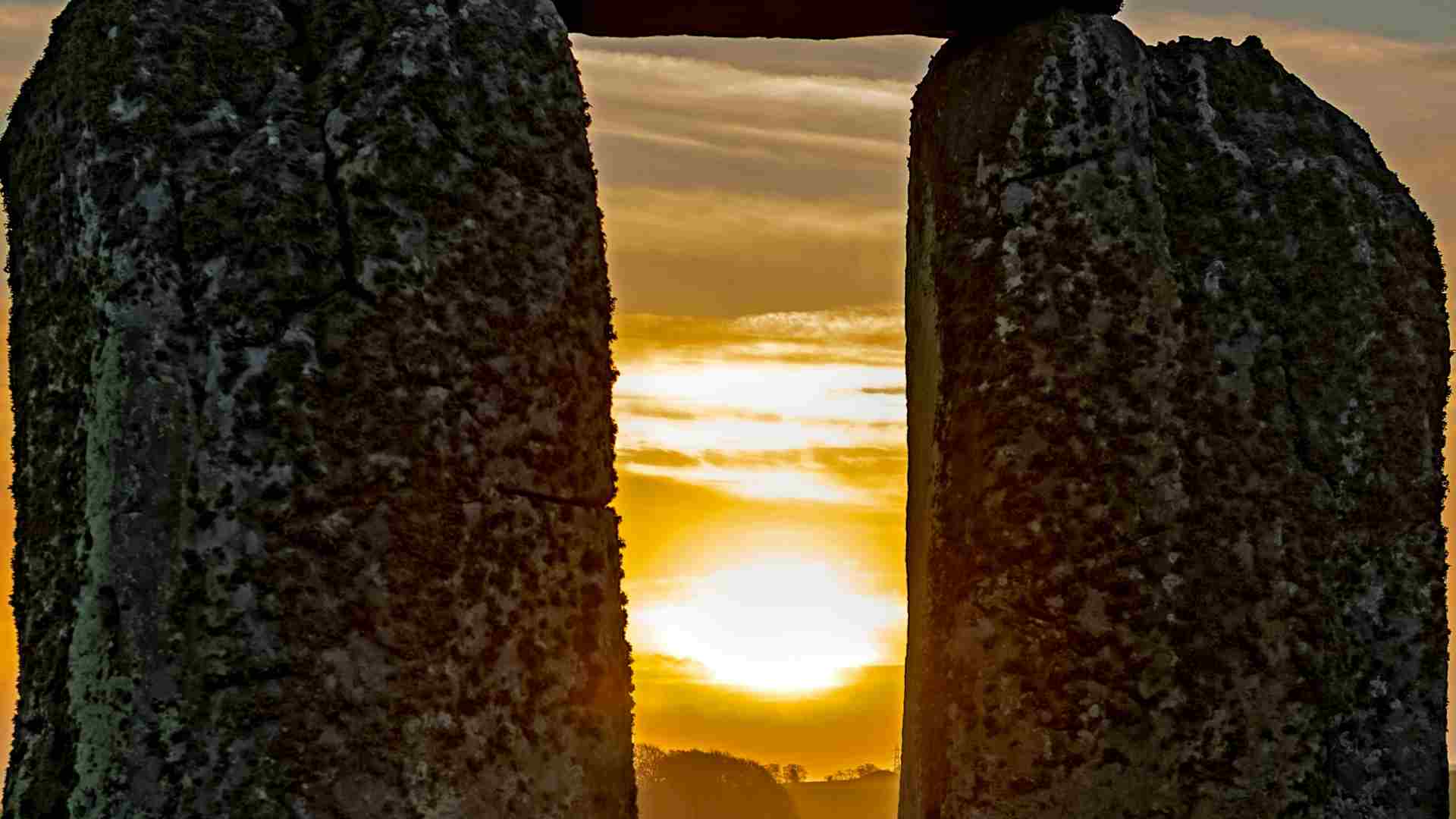 A close-up look at a sunset between stones at Stonehenge.