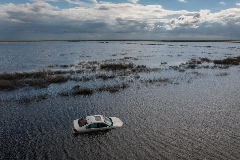 In an aerial view, a car is left stranded in widespread flooding as a series of atmospheric river storms melts record amounts of snow in the Sierra Nevada Mountain, Tulare Lake