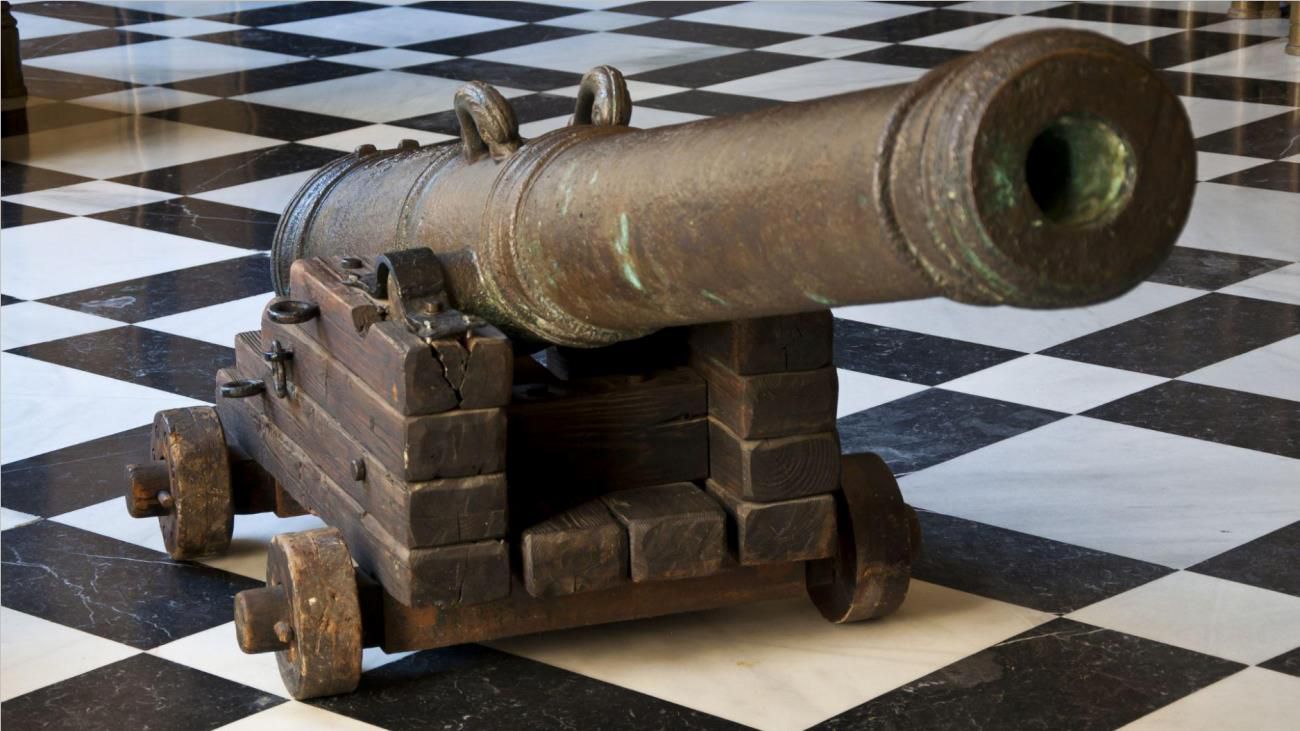A large bronze cannon that was found in the Nuestra Señora de Atocha shipwreck on a black and white flooring
