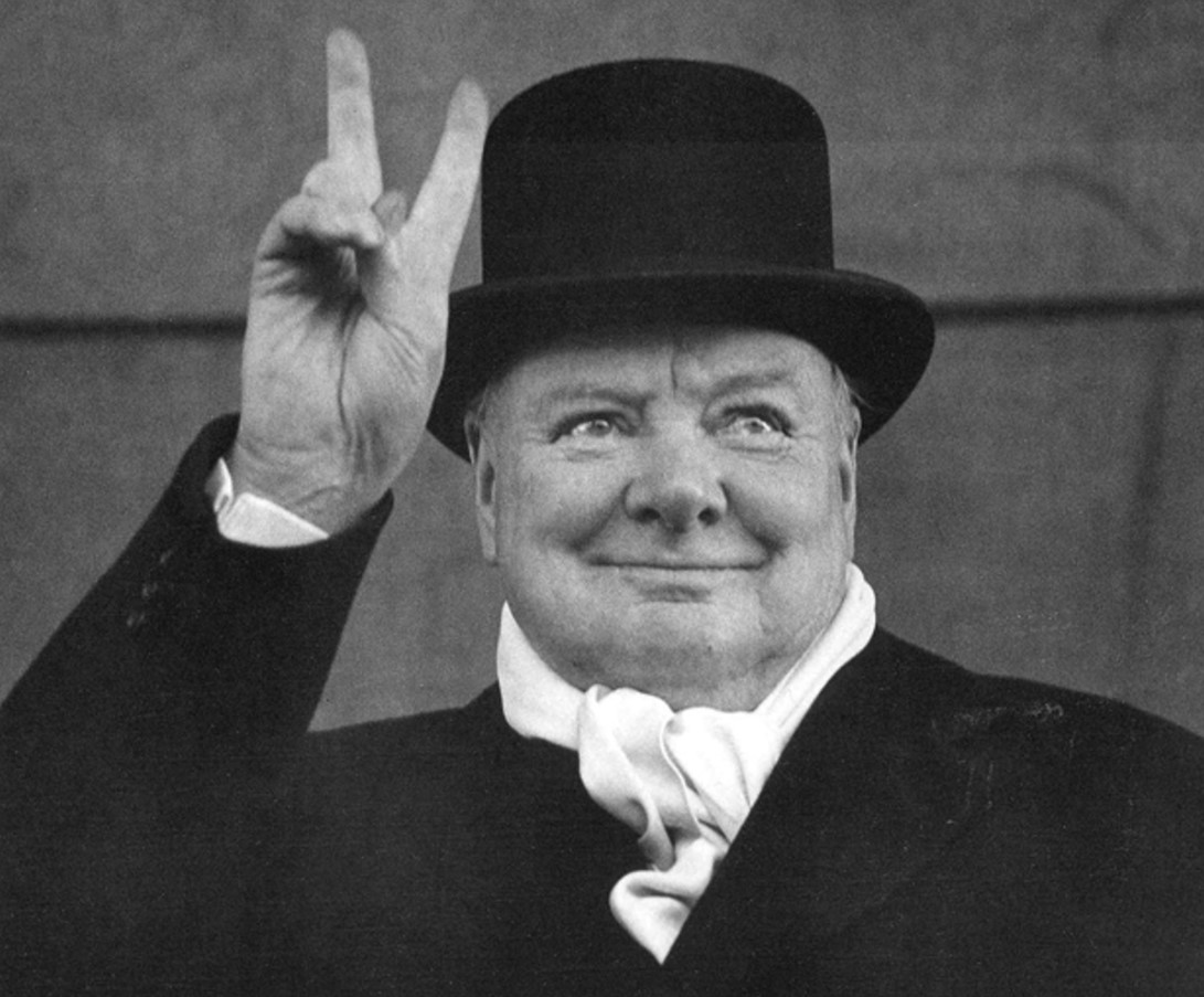 Winston Churchill makes the peace sign and smiles to a crowd in England