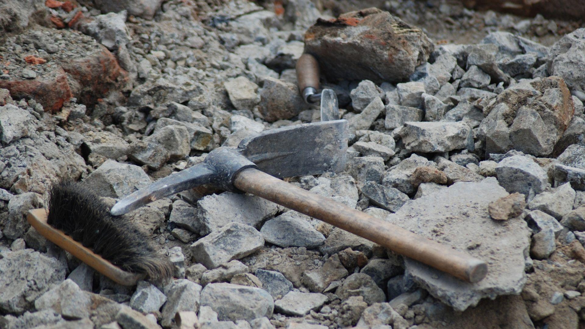 A close-up of archeological tools lying on rocks and dirt.