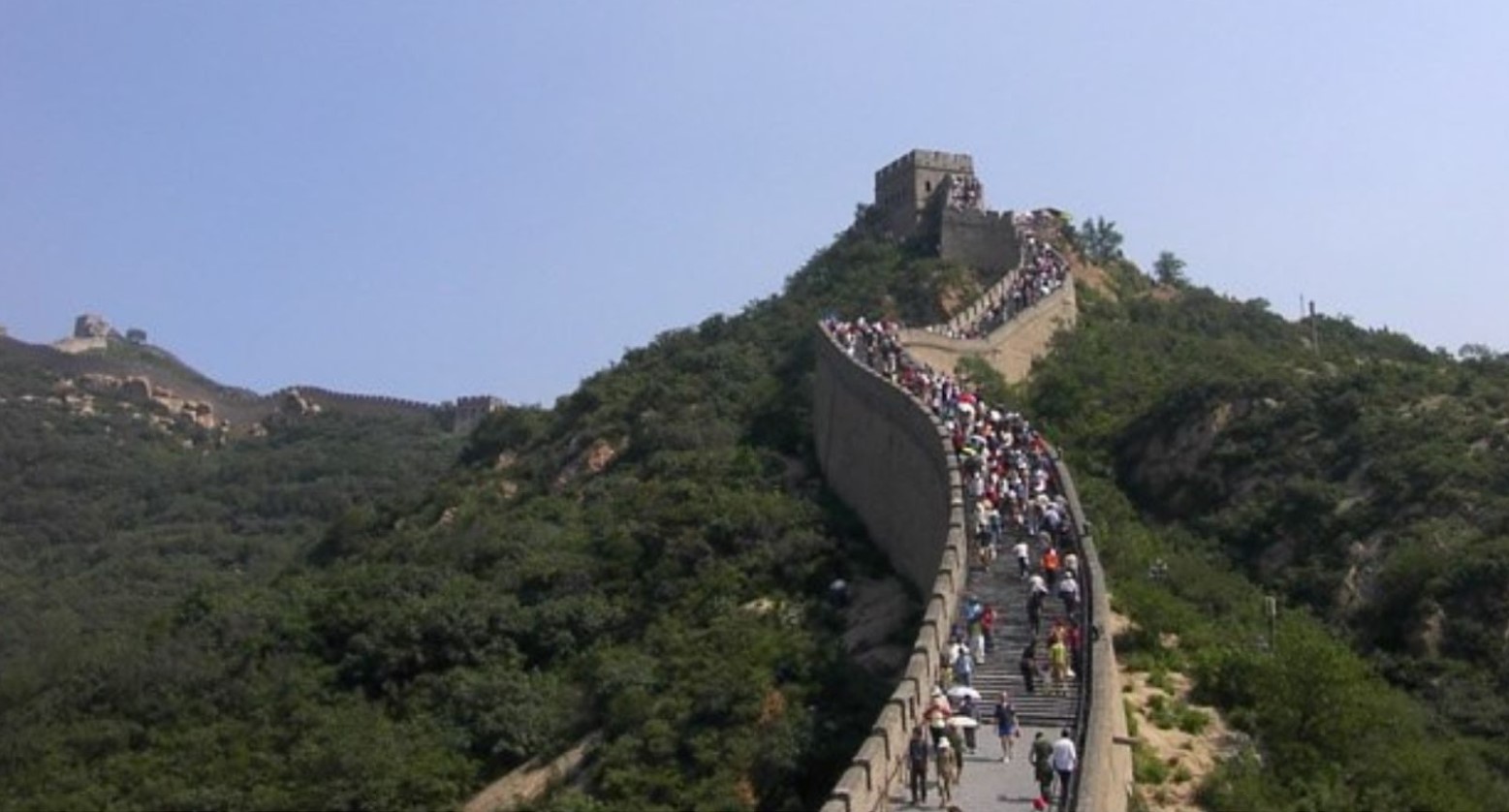 The Badaling section of the Great Wall of China. There are crowds of people walking up the wall.