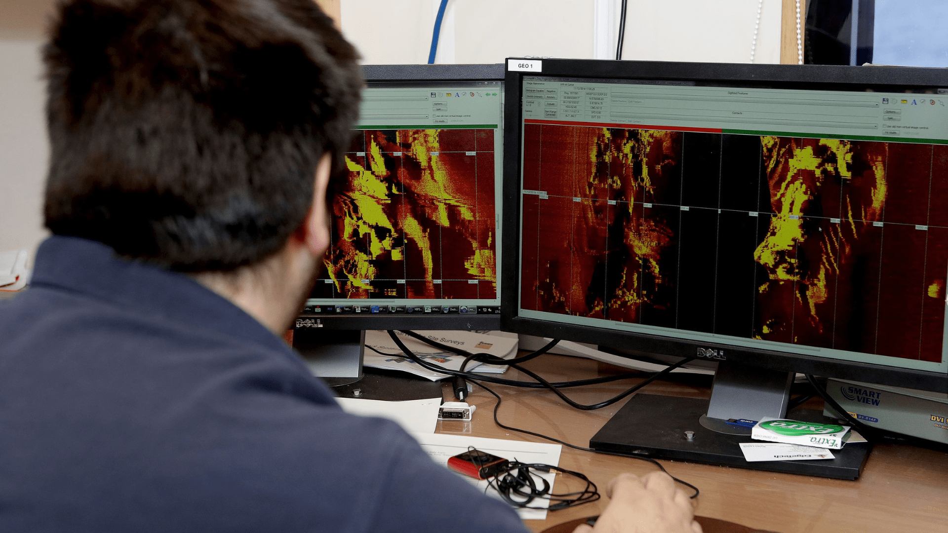 A specialist operator looks at two computer monitors, processing data received from the Dragon Prince deep towfish during Fugro Discovery’s search for the missing Malaysia Airlines flight MH370.