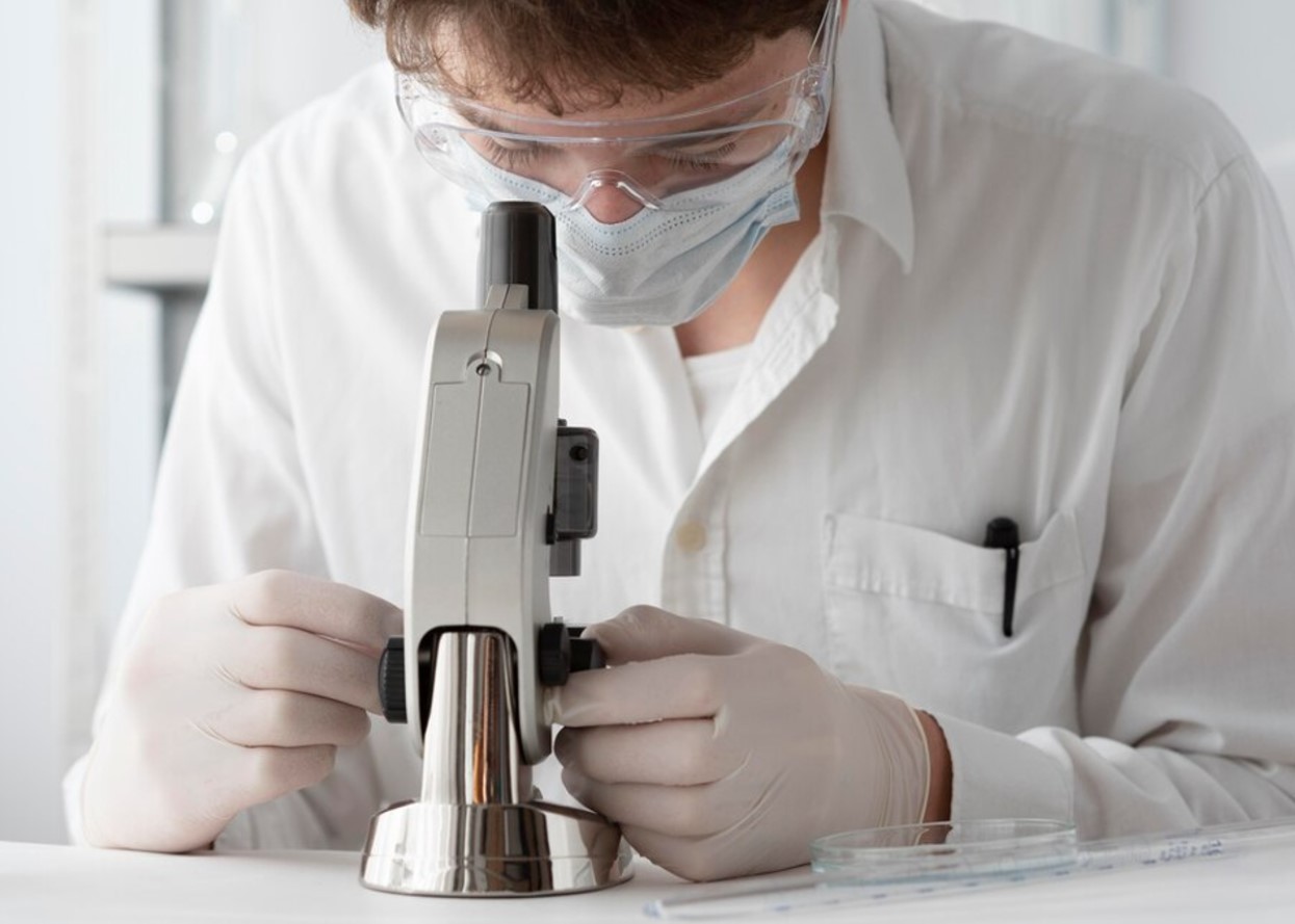 Male scientists analyzing a sample under a microscope