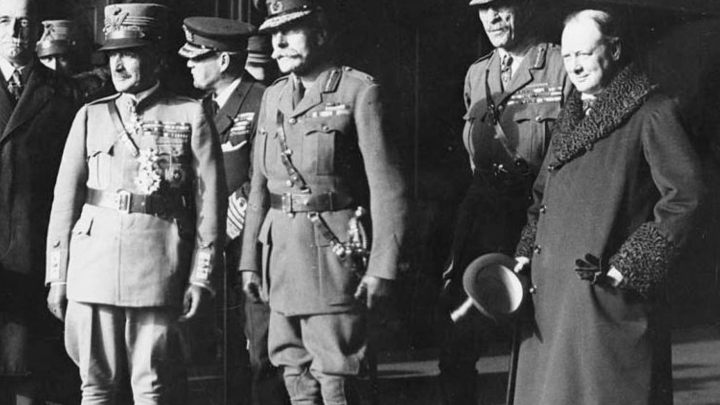 A black and white photo showing Field Marshal Haig, along with a mix of military and civilian dignitaries. Among them is a French general. Sir Winston Churchill is present, positioned on the right side of the frame