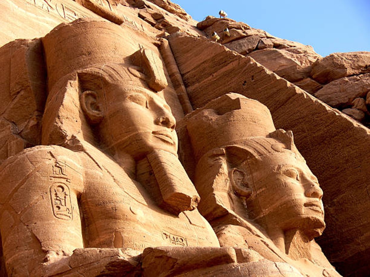 Statues of the pharaohs of Ancient Egypt along the outside of a pyramid