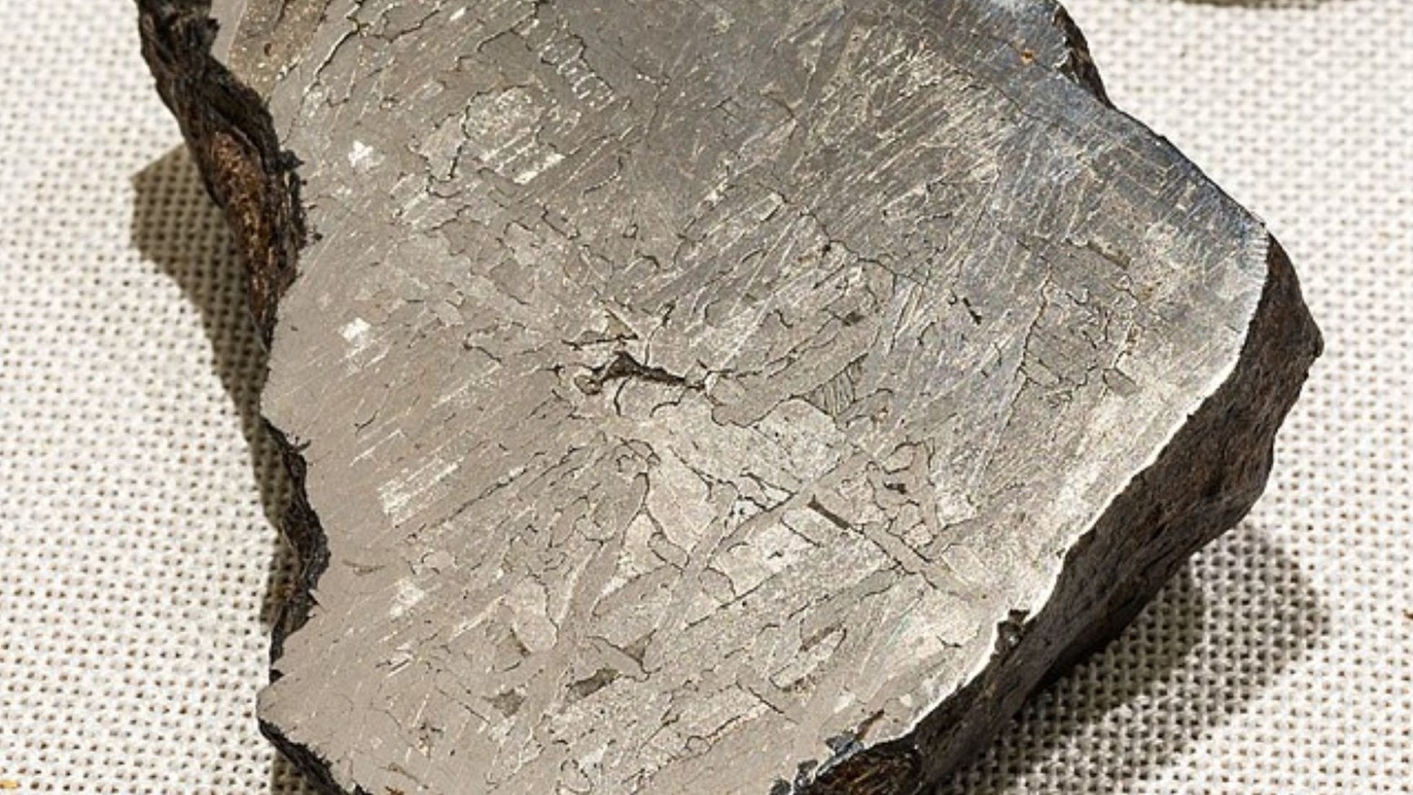 An example of meteorite iron on a white background. The color of the meteorite is grey.