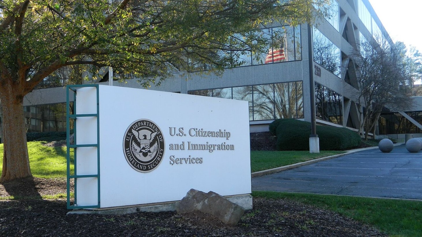The entrance sign of the U.S. Citizenship and Immigration Services building, featuring the department's seal