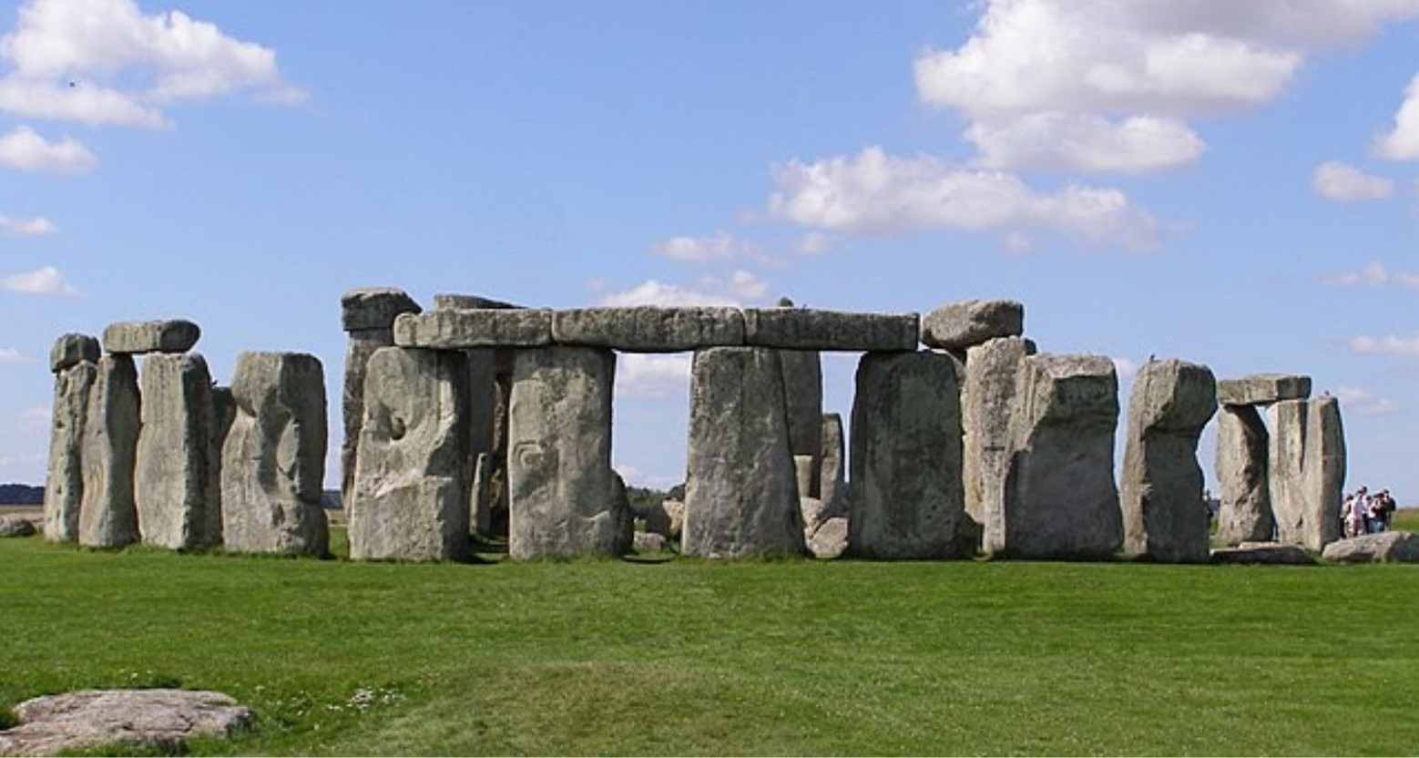 Stonehenge on a sunny day. The stones are in a circle, with some on top of each other.