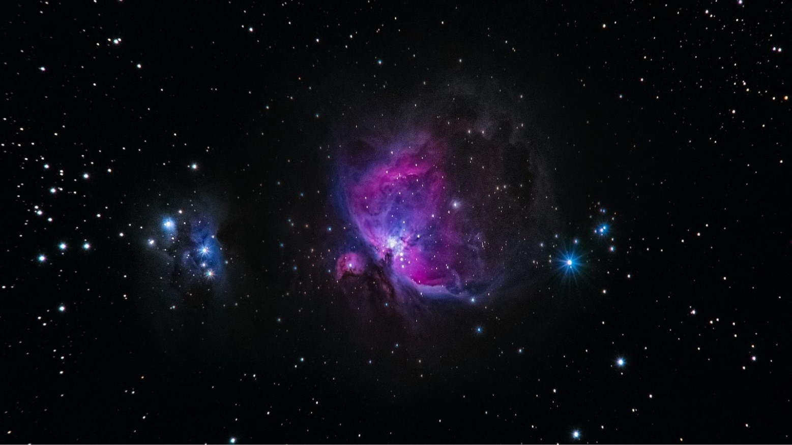 A picture of colorful blue and purple nebulas in black space by stars.