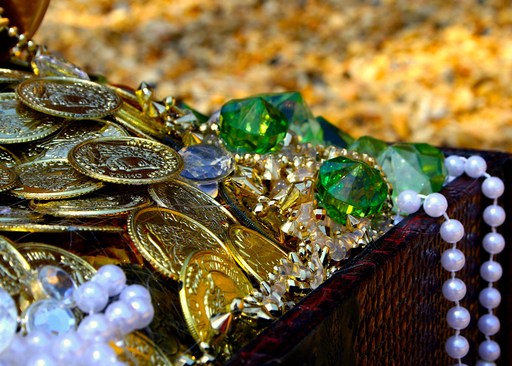 A close up of gold and emeralds in a treasure chest