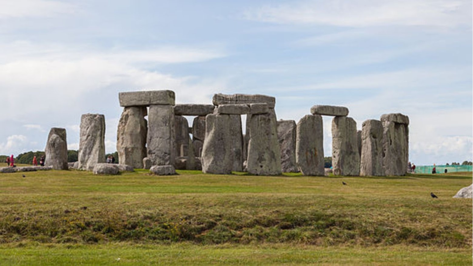 Stonehenge from a distance. Some people can be seen in the background looking at the stones.