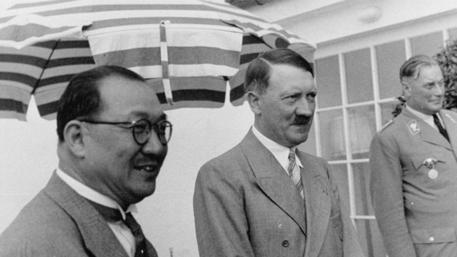 A black and white photo of Adolf Hitler by other men.