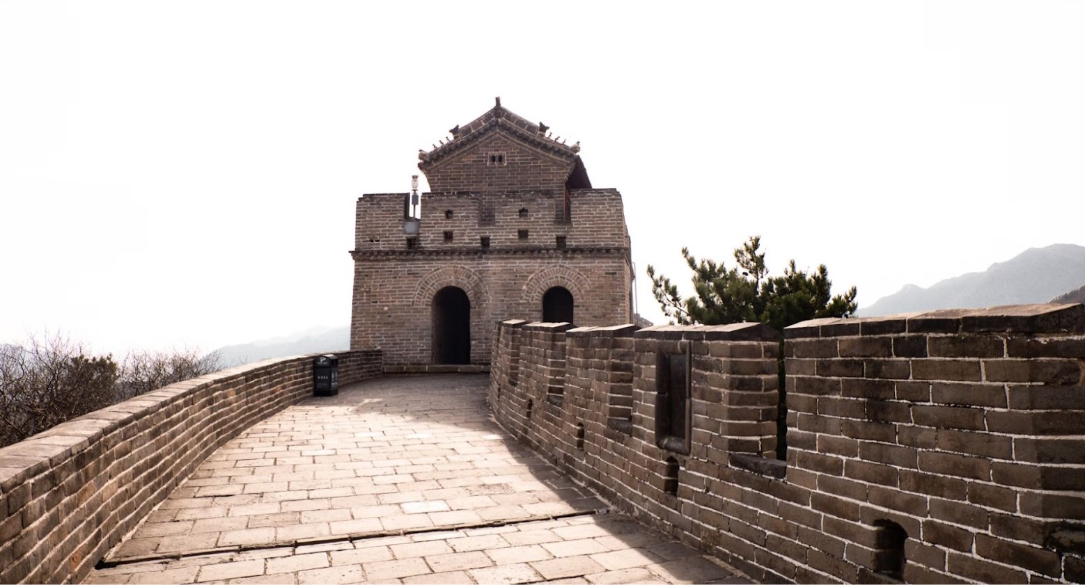 An image of the Great Wall of China from inside the wall. It is leading up to a building within the wall.