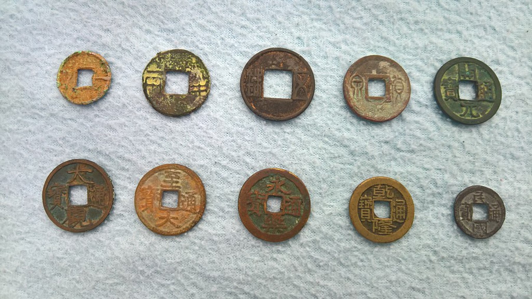 A selection of ancient Chinese coins laid out on a small table