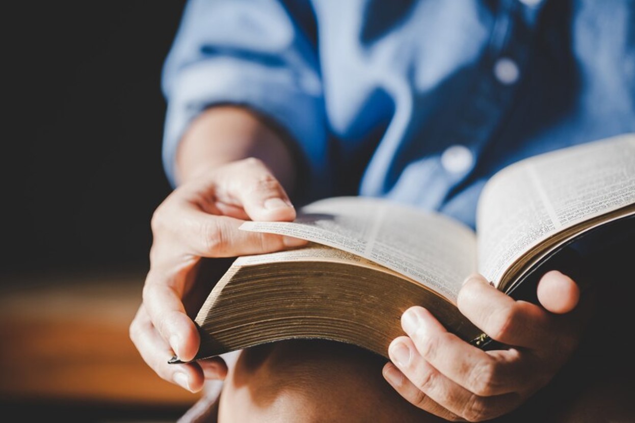 Faceless man reading the Bible