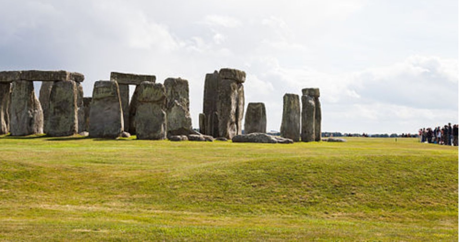 Stonehenge during the day. There is a crowd of people to the right-hand side of the stones.