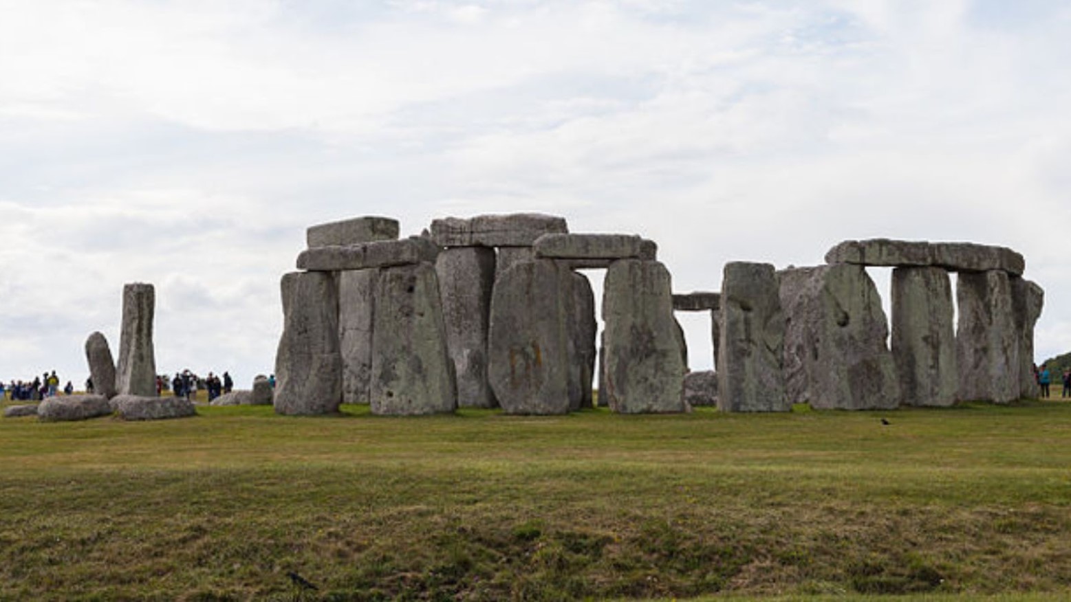 Stonehenge during the day. In the background, some people are looking at the stones.