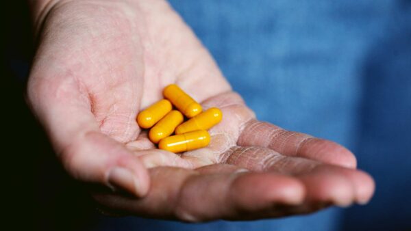 Pill capsules contained in the palm of someone's hand.