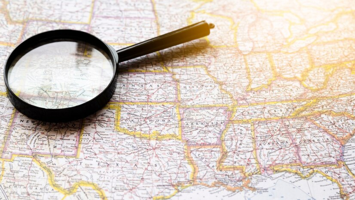 Map of the United States with a magnifying glass laying on top