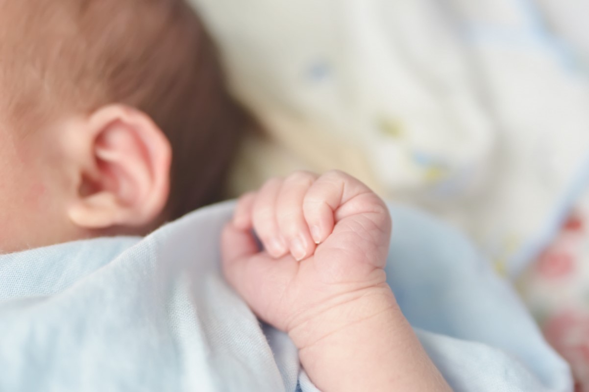 Photograph of a small child with its arm raised