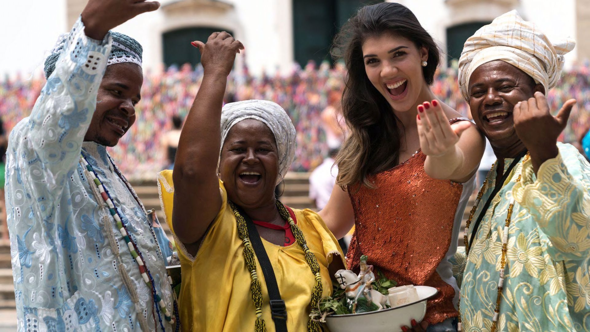 Four people celebrating Indian culture in bright colors raising hands