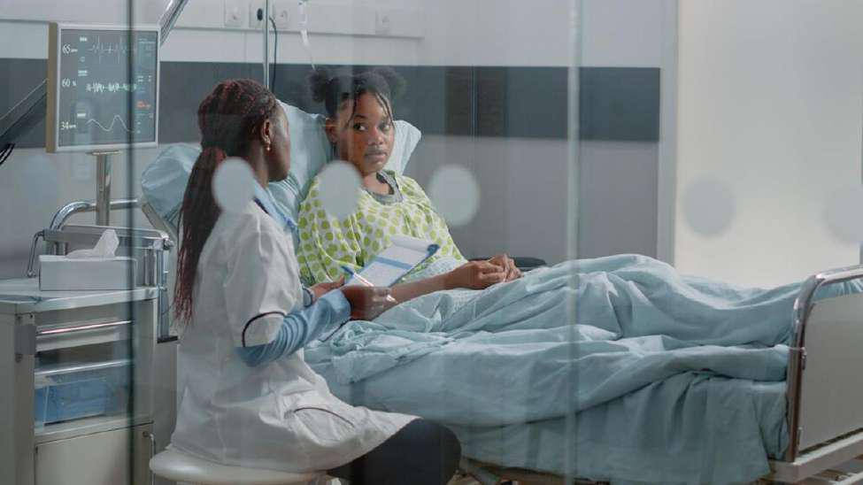 Doctor speaks with a young patient in the hospital